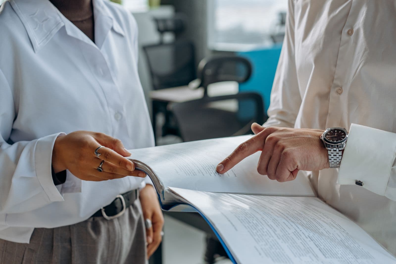 Two people going through a printed document together at an office