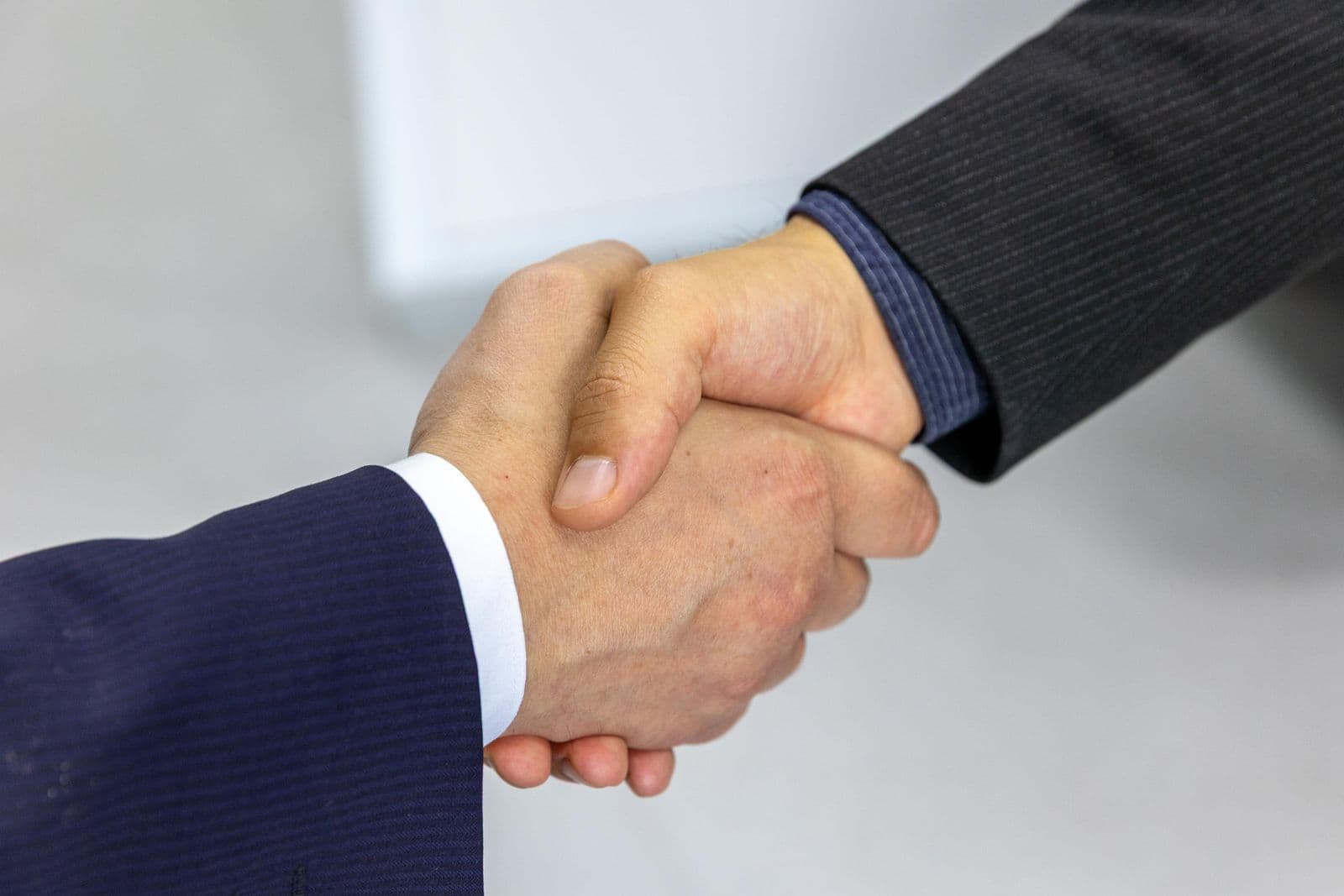 Two people shaking hands in business clothes
